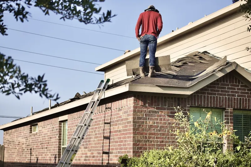 Professional roofer working on a residential roof in Riverdale